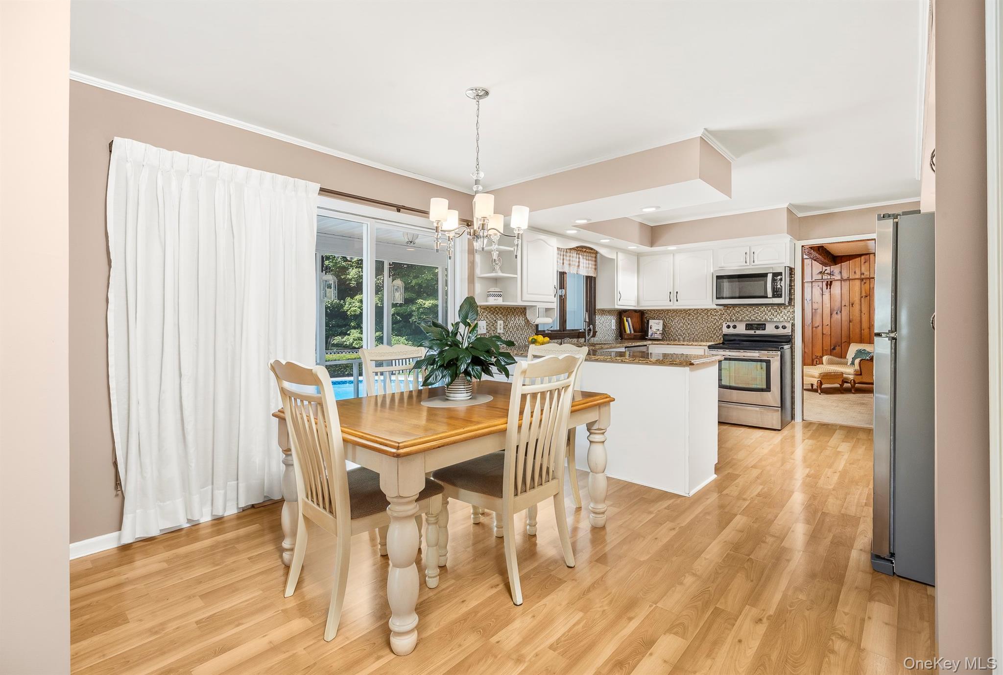 75 Hornbeck Road Poughkeepsie, NY 12603 - Photo 19 of 36 a dining room with stainless steel appliances kitchen island granite countertop a table chairs and a wooden floor