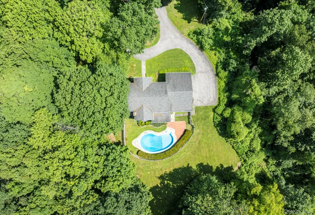 a aerial view of a house with swimming pool and large trees
