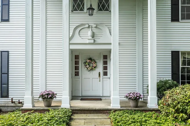 a front view of a house with a potted plant