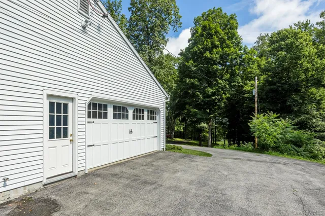 a view of a white house with a large window and large tree