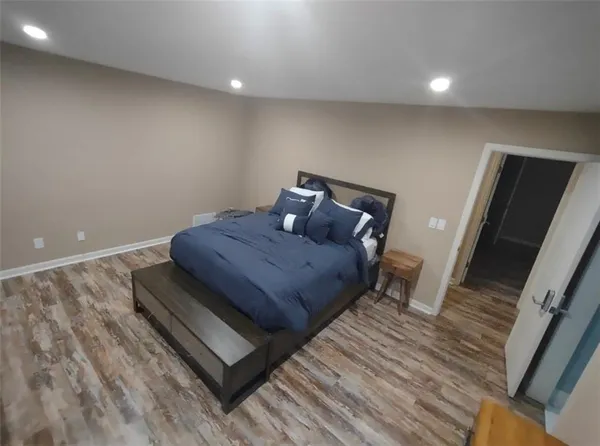 a bedroom with a bed and wooden floor