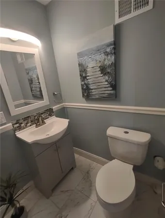 a bathroom with a toilet sink and mirror