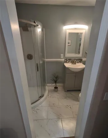 a bathroom with a sink a toilet and shower