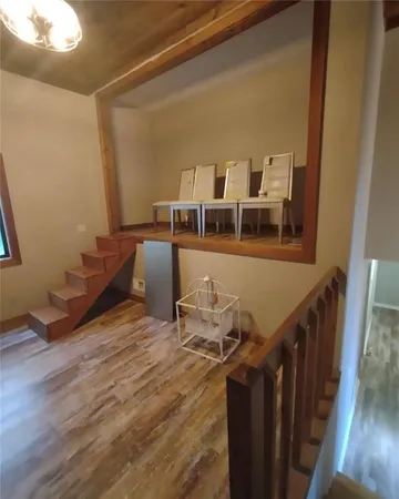 a living room with chairs and wooden floor