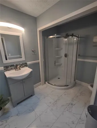 a bathroom with a sink a toilet and shower