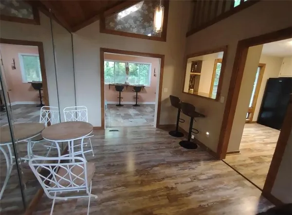 a view of a dining room with furniture a chandelier and wooden floor