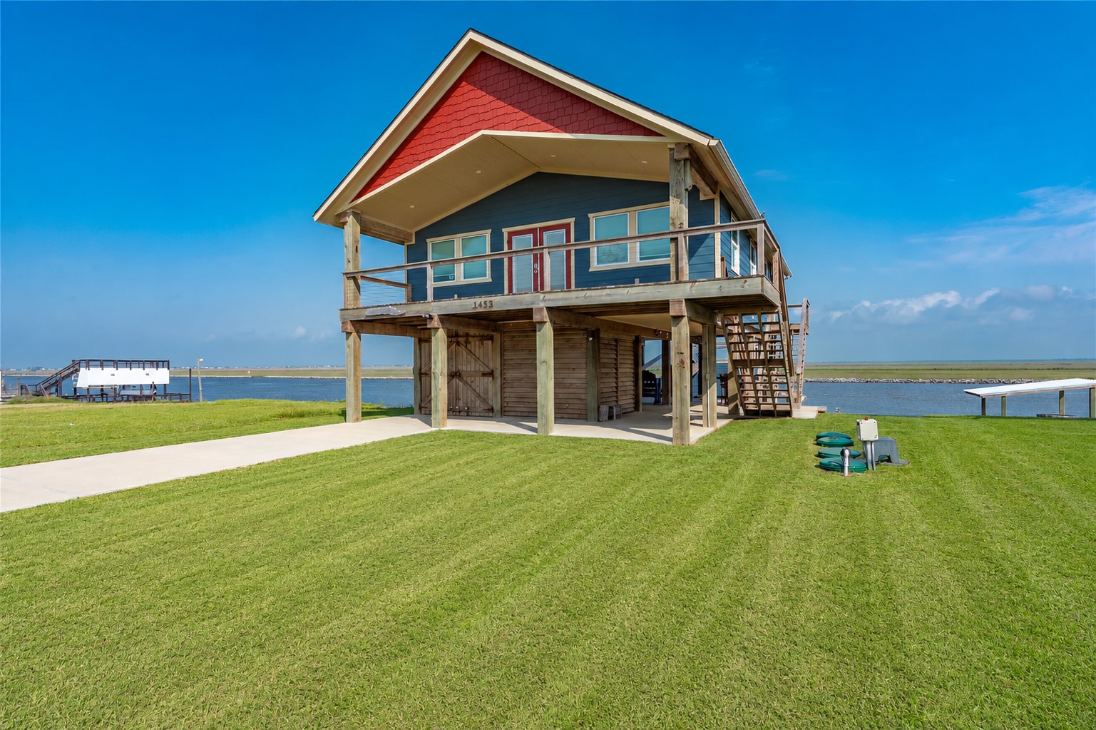 1453 County Road 230 Sargent, TX 77414 - Photo 1 of 38 Waterfront Home — This charming waterfront stilt home features expansive decks and beautiful water views, creating a relaxed coastal lifestyle. Landscaping was virtually enhanced to showcase the property's full potential
