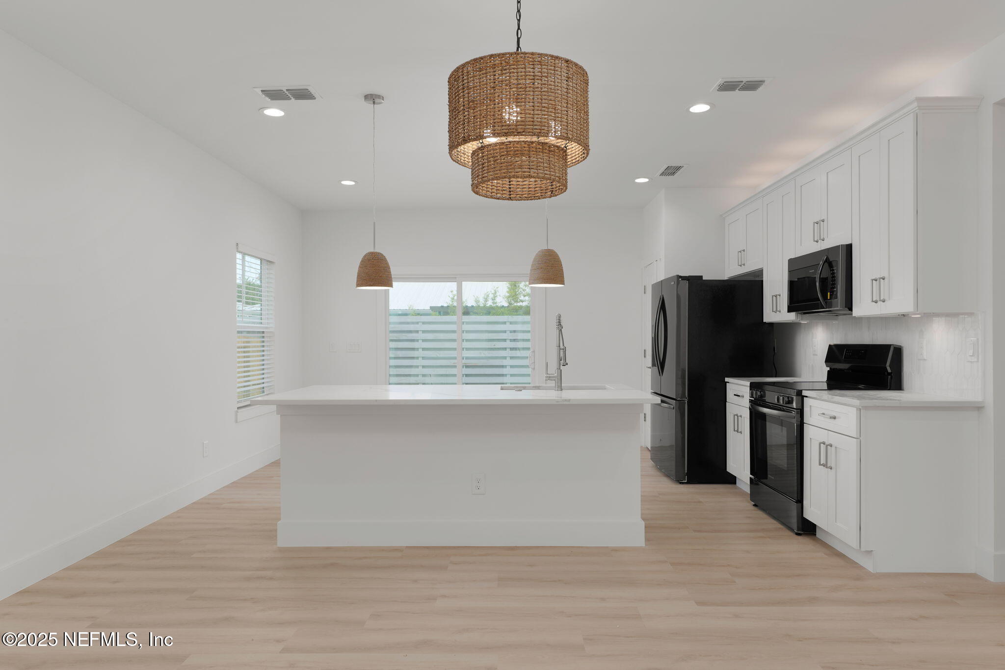 603-609 Twenty Second Street St. Augustine, FL 32084 - Photo 15 of 36 a kitchen with stainless steel appliances granite countertop a refrigerator a stove a sink and a microwave