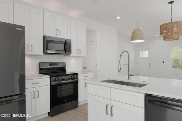 a kitchen with appliances a sink and cabinets