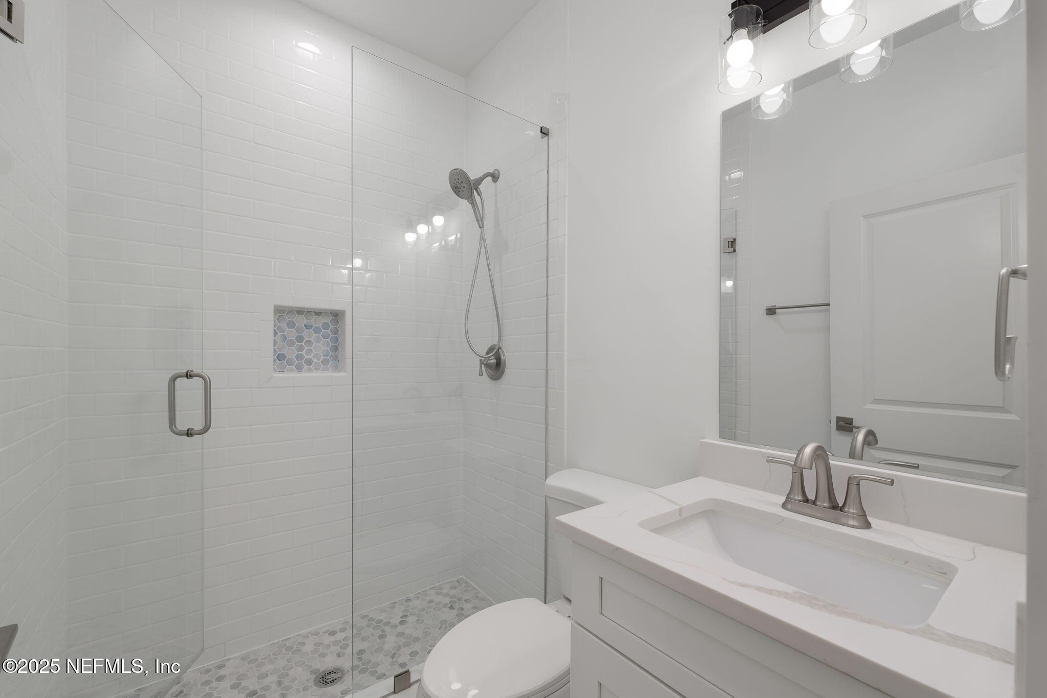 603-609 Twenty Second Street St. Augustine, FL 32084 - Photo 33 of 36 a bathroom with a toilet sink a mirror and shower