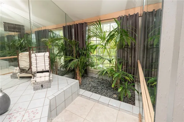 a living room with furniture a rug and a floor to ceiling window