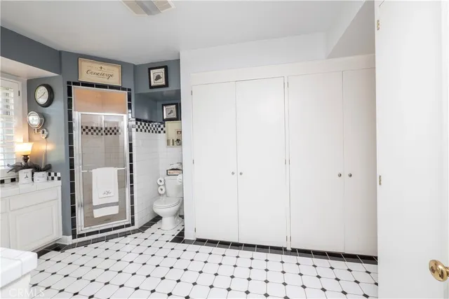 a spacious bedroom with a bed and a chandelier