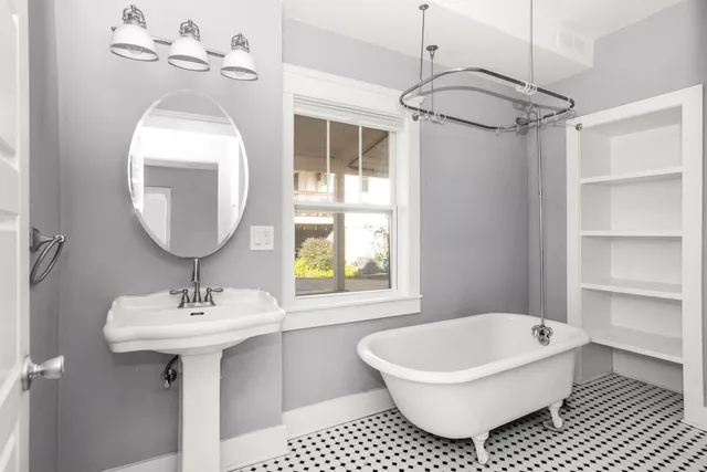 a bathroom with a sink toilet a mirror and bathtub