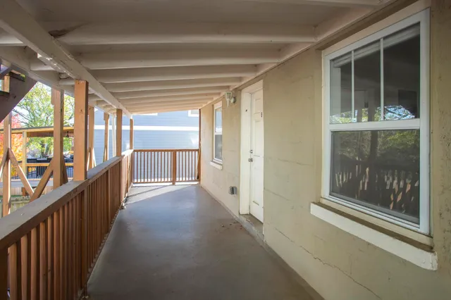 a view of a hallway with wooden floor and windows