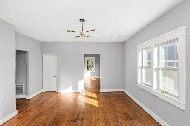 a view of empty room with wooden floor and window