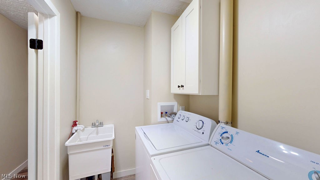 18620 Shaw Road Chagrin Falls, OH 44023 - Photo 28 of 44 Dedicated laundry area featuring a utility sink, upper cabinetry, and wood-finish flooring