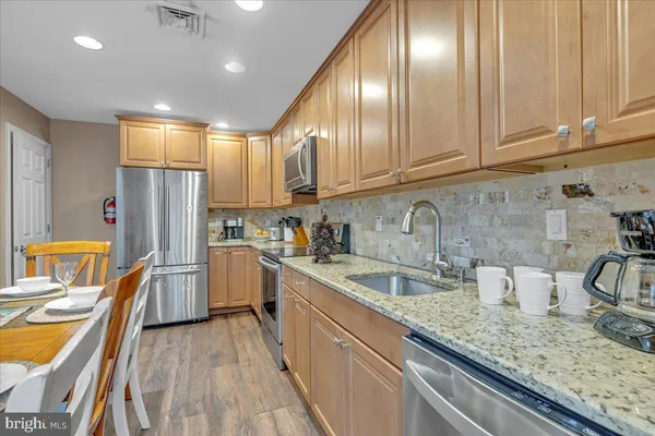 a room with wooden floor pool table and windows