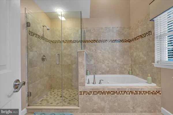 a bathroom with a granite countertop sink a mirror a vanity and a bathtub