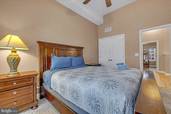 a bedroom with a bed a window and a flat screen tv