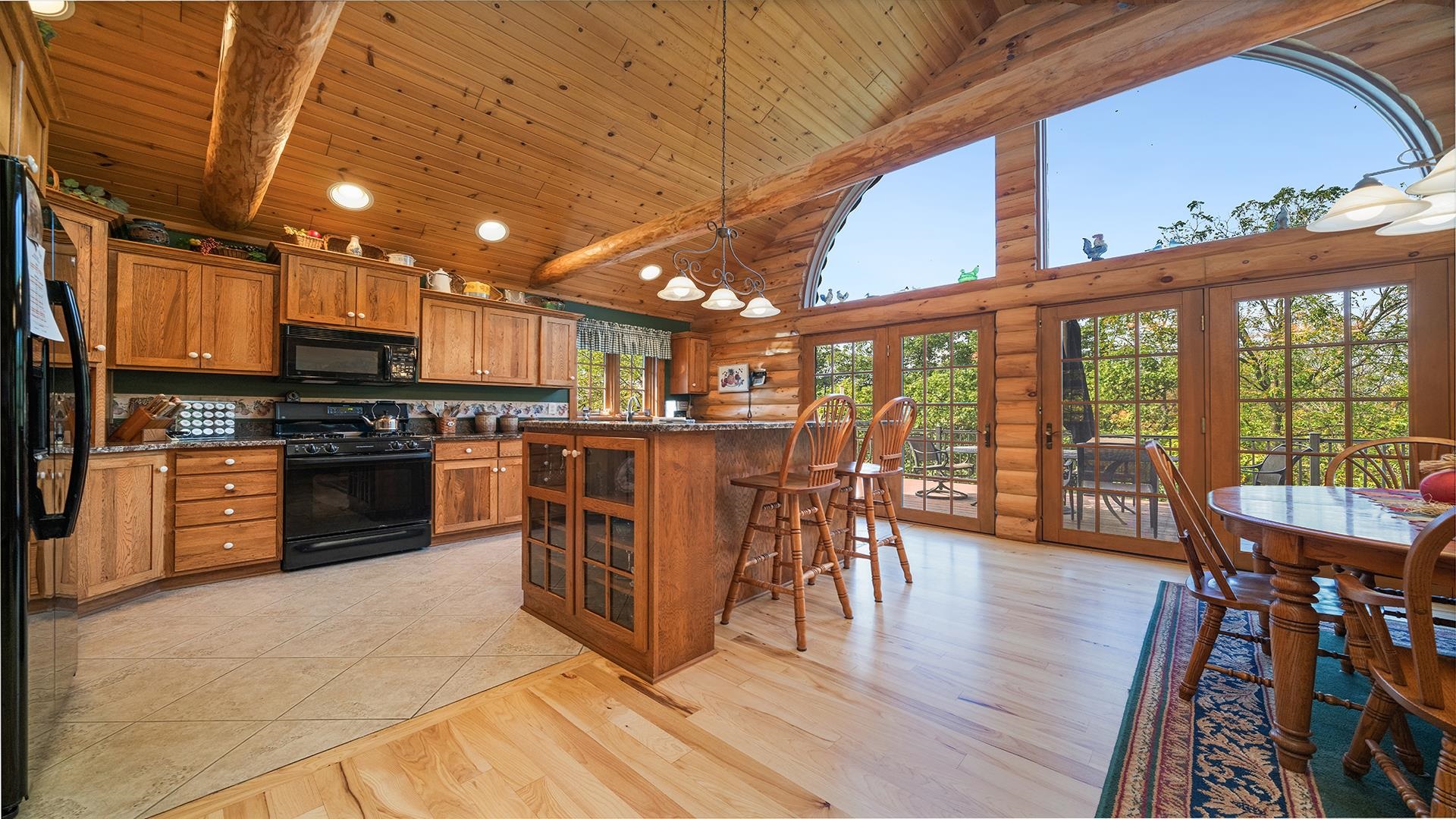 5810 West Lightsville Road Leaf River, IL 61047 - Photo 17 of 68 a kitchen with stainless steel appliances granite countertop a stove top oven a dining table and chairs with wooden floor