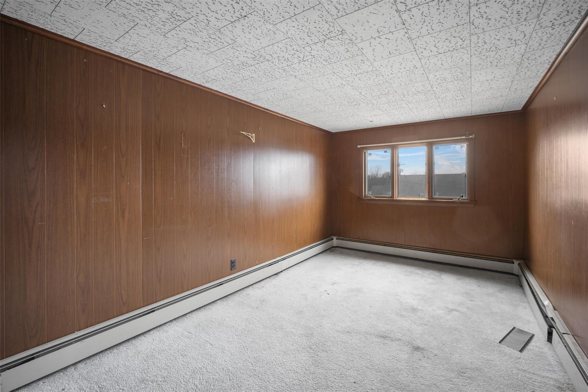 79 Maple Avenue Catskill, NY 12414 - Photo 14 of 35 Spare room with baseboard heating, wooden walls, and carpet
