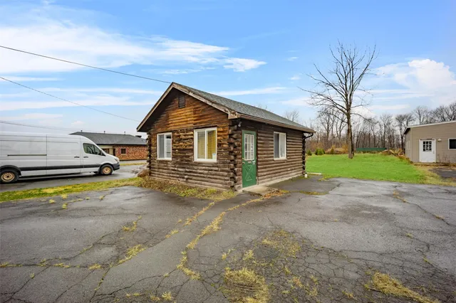 a view of a house with a big yard and large trees