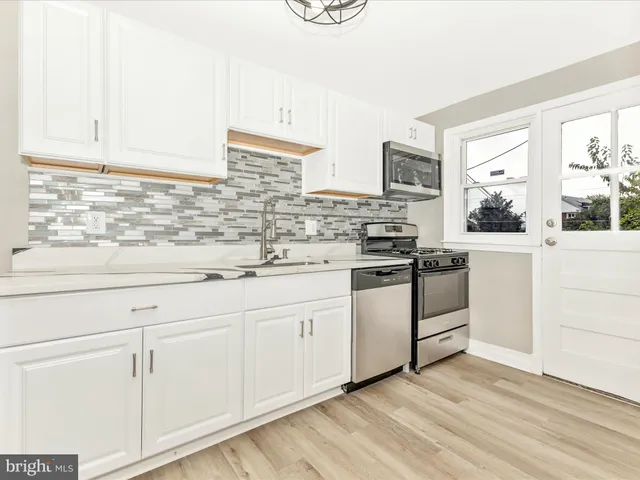 a kitchen with granite countertop white cabinets and white appliances