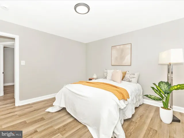 a bedroom with bed and a potted plant
