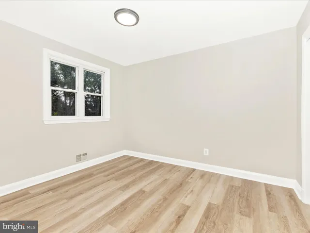 a view of a room with wooden floor and window