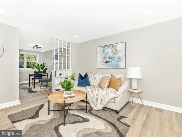 a living room with furniture a lamp and a potted plant