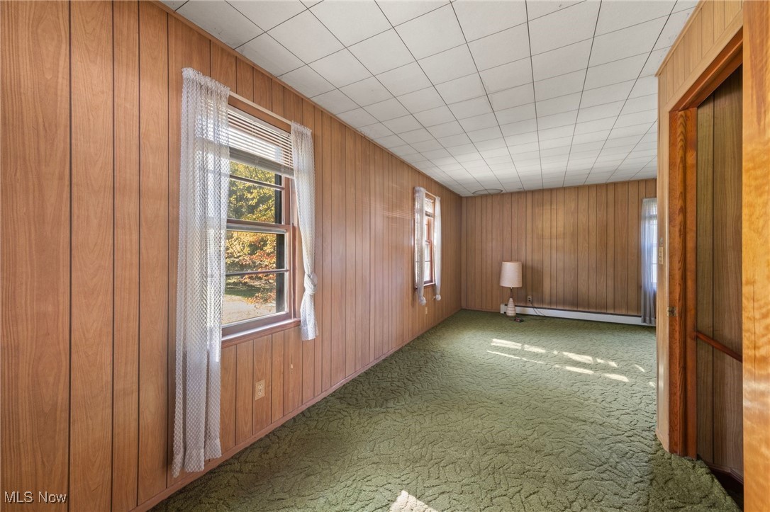2846 Barber Road Barberton, OH 44203 - Photo 21 of 29 Main bedroom featuring a wealth of natural light, wooden walls, and baseboard heating
