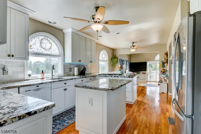 a kitchen with a stove a sink and a wooden floor