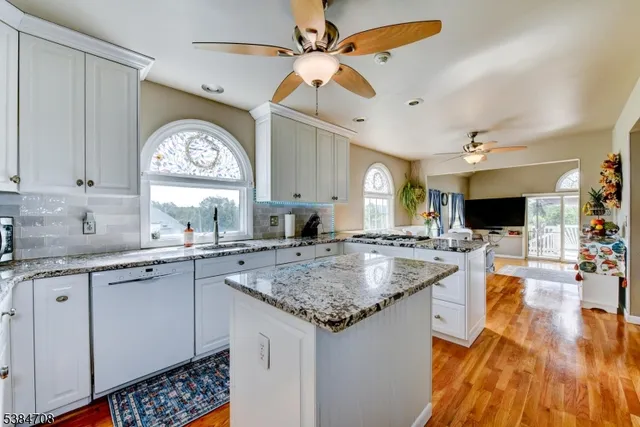 a kitchen with a sink a counter space and a view of living room