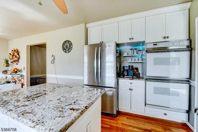 a kitchen with stainless steel appliances granite countertop a refrigerator and a stove