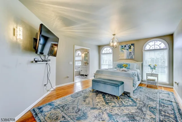 a spacious bedroom with a bed a mirror and a window