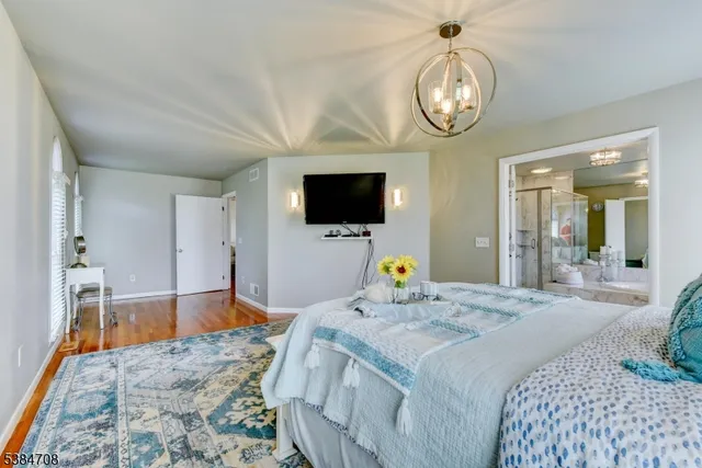a bedroom with a bed and a flat tv screen on dresser