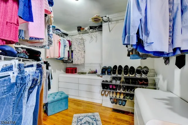 a view of walk in closet with clothes and shoes