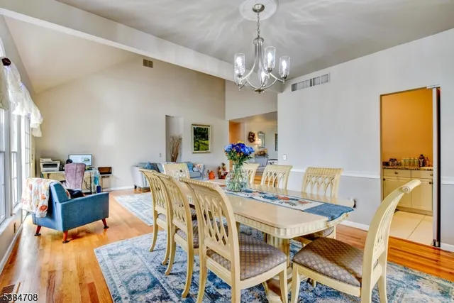 a view of a dining room with furniture and a chandelier