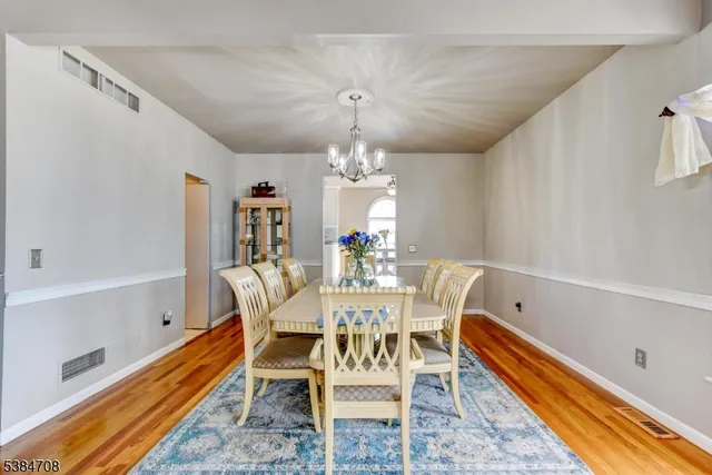 a dining room with furniture a chandelier and wooden floor