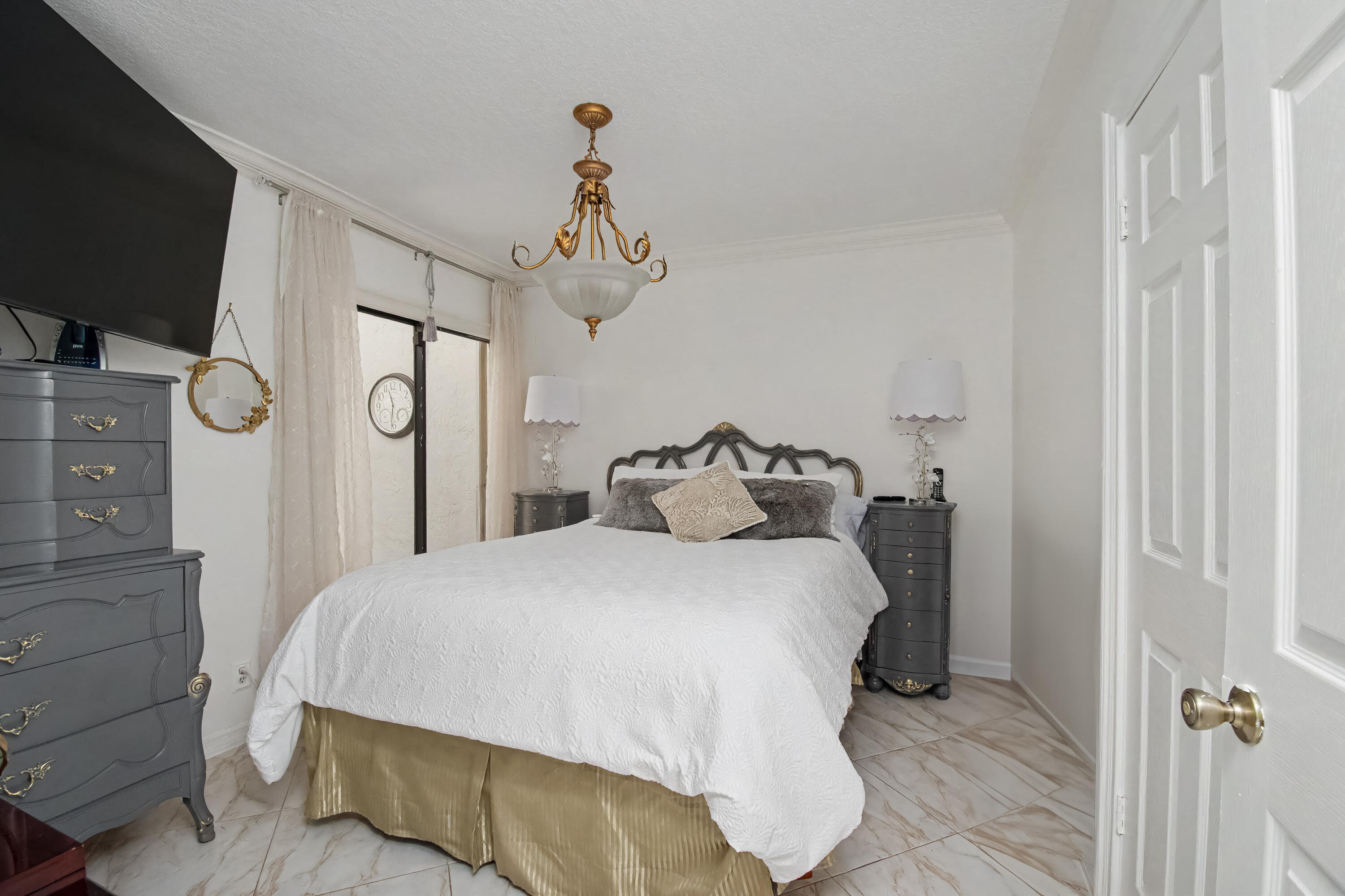9708 Erica Court Boca Raton, FL 33496 - Photo 35 of 54 a bedroom with a bed and a flat tv screen on dresser