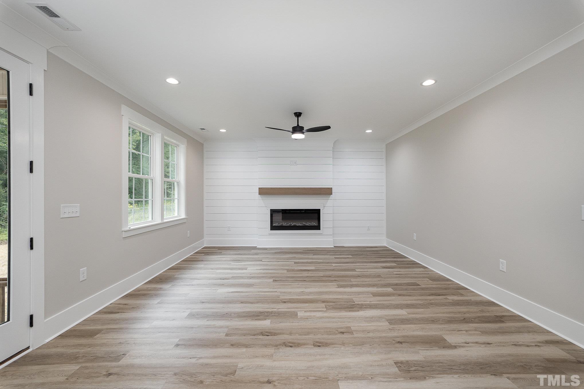 1291 Massengill Pond Road Angier, NC 27501 - Photo 17 of 45 a view of an empty room with a fireplace and a window