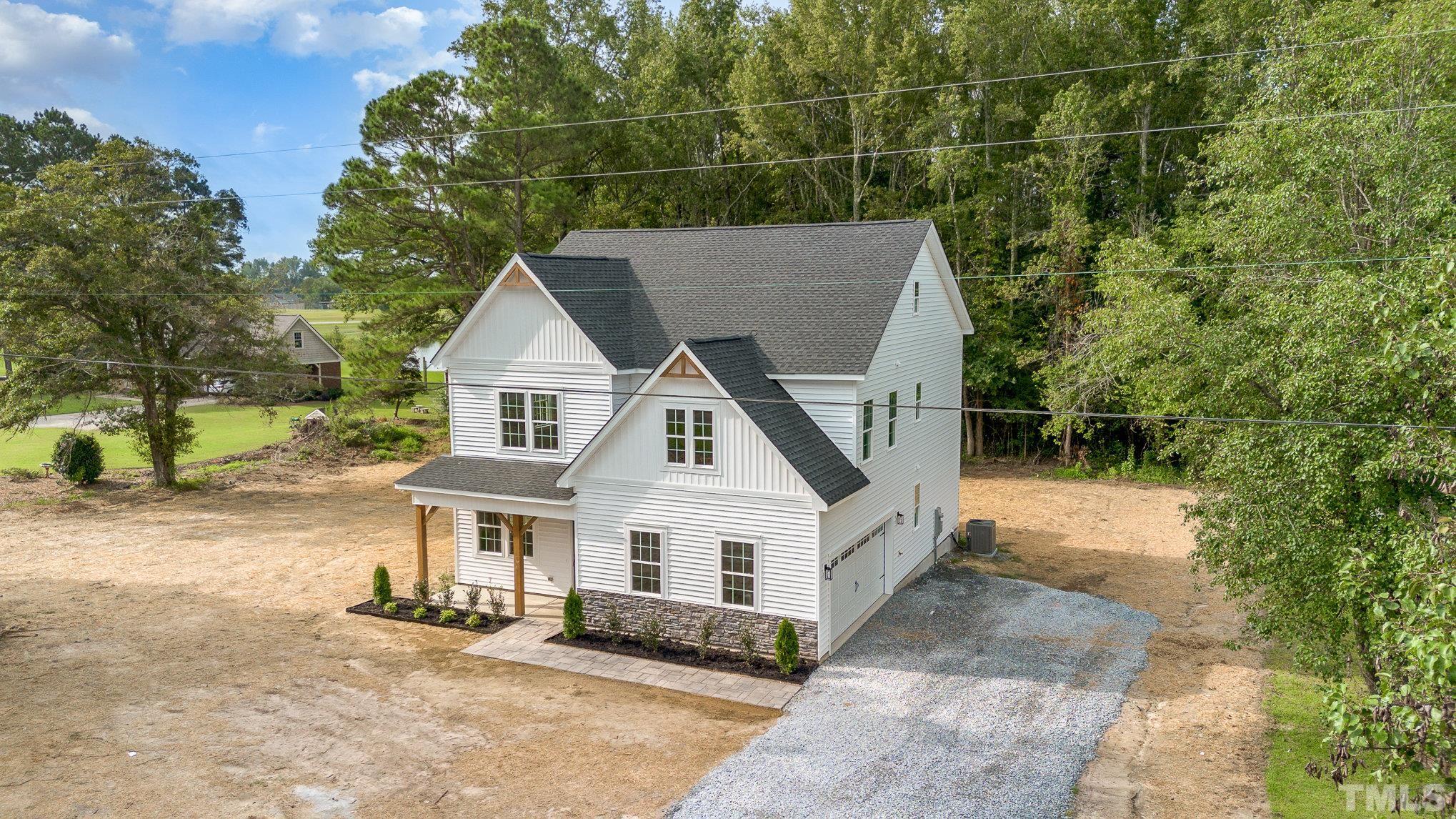1291 Massengill Pond Road Angier, NC 27501 - Photo 4 of 45 a view of a white house with a yard and potted plants