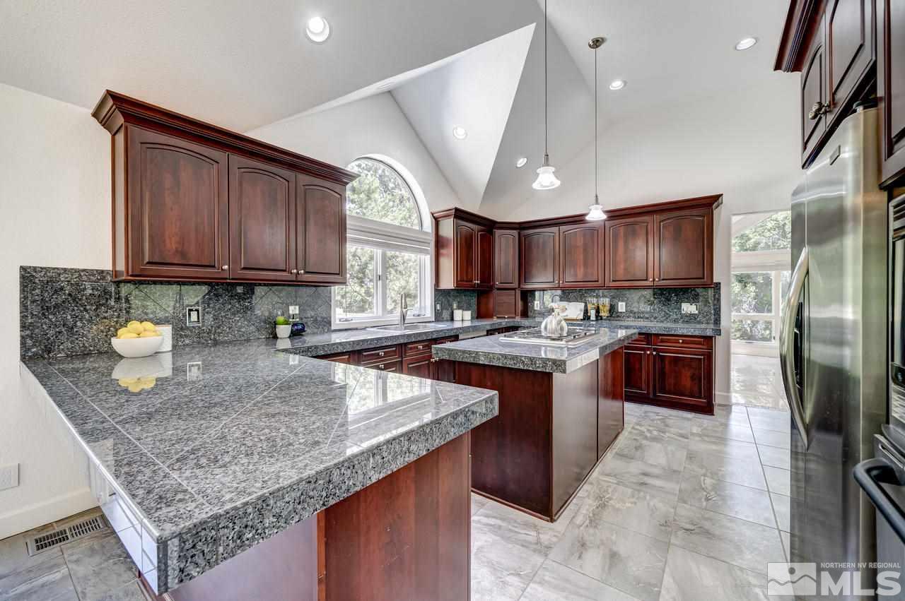 4286 Caughlin Parkway Reno, NV 89519 - Photo 7 of 25 a kitchen with stainless steel appliances granite countertop a stove a sink dishwasher a refrigerator and a oven with wooden cabinets