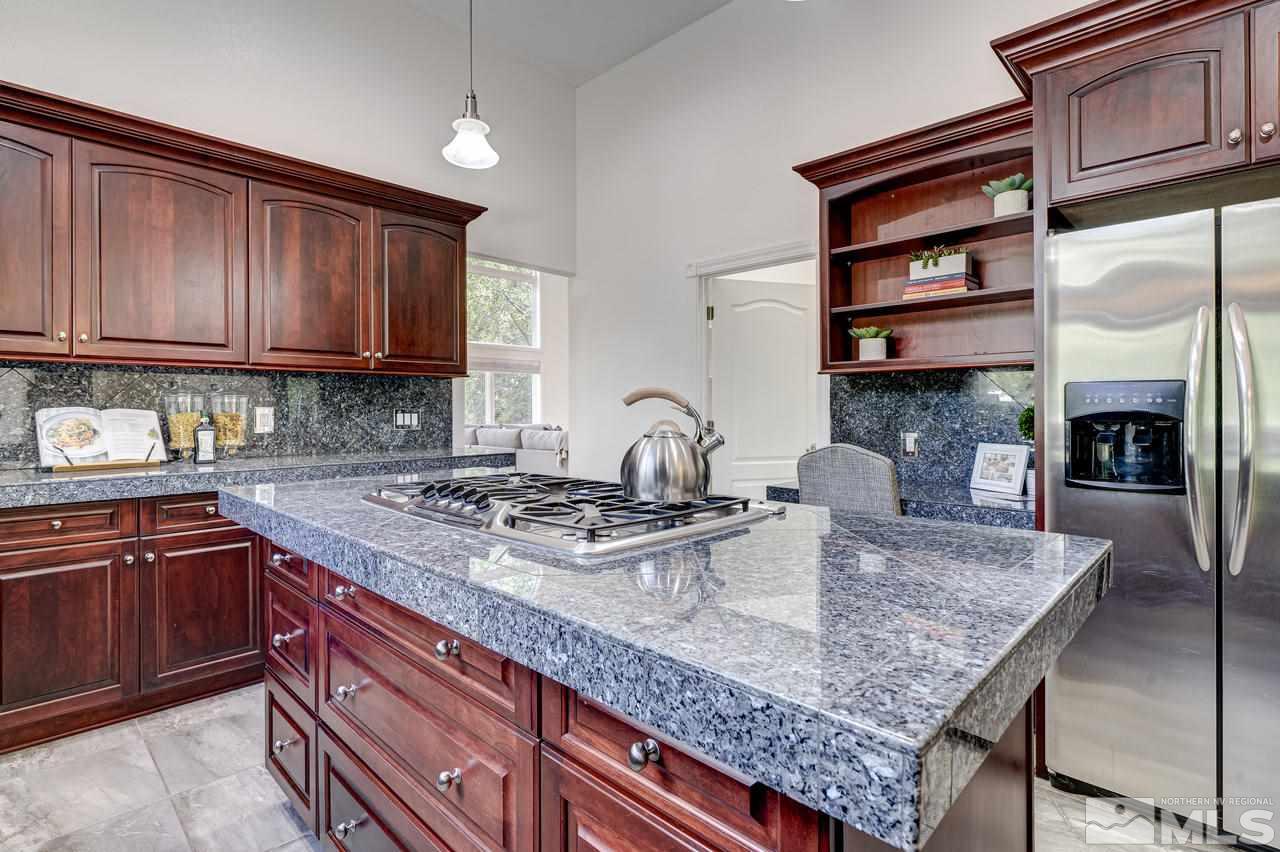 4286 Caughlin Parkway Reno, NV 89519 - Photo 8 of 25 a kitchen with granite countertop a stove a sink and dishwasher wooden cabinets with granite countertops