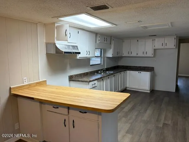 a kitchen that has a sink a stove and cabinets