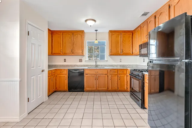 a kitchen with stainless steel appliances granite countertop a sink counter space cabinets and a window