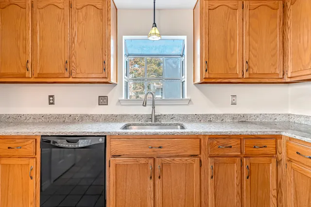 a kitchen with stainless steel appliances granite countertop a sink and a cabinets with wooden floor