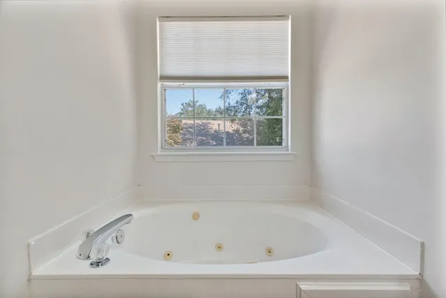 a bathroom with a tub and a window