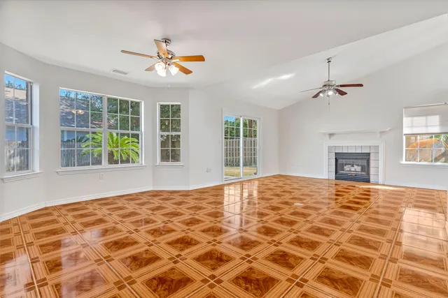 a view of an empty room with a fireplace and a window