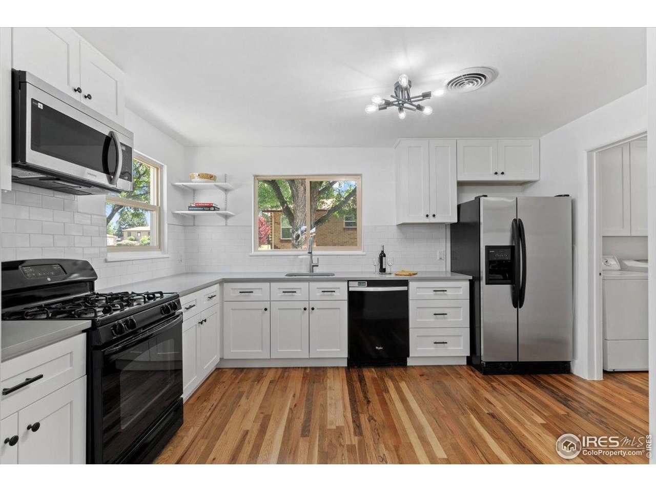 4125 Pierce Street Wheat Ridge, CO 80033 - Photo 11 of 45 a kitchen with granite countertop a refrigerator stove top oven and sink